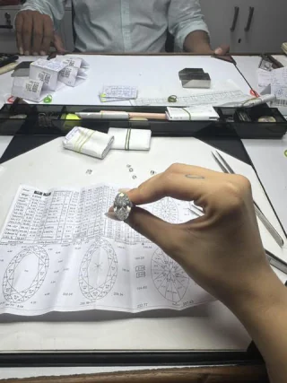 A diamond held above a printed grading sheet with proportion diagrams