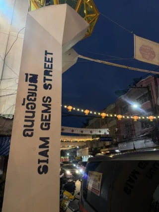 A gem trading street at dusk under strung lights