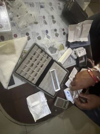Paper parcels and a stone tray open on a trading table